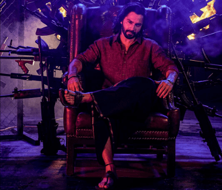 A man in a chair, with multiple guns